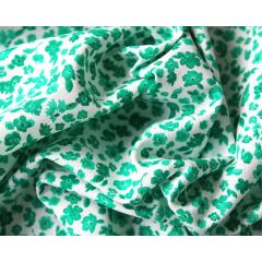 White chiffon fabric scattered with tiny purple and pink flowers and green leaves.