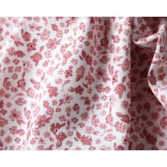 White chiffon fabric scattered with tiny purple and pink flowers and green leaves.