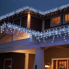 Outdoor house decorated with cool white LED icicle lights along the gutters and roofline