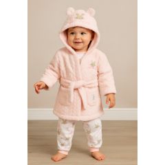 Baby girl wearing a light pink hooded bathrobe with embroidered bunny design and matching printed cotton pyjamas featuring cute bunny and floral patterns, standing on a soft wooden floor.