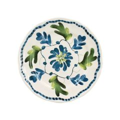 A round ceramic plate with blue and green floral patterns and a wavy blue border on a white background.