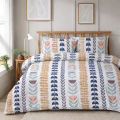 A neatly made bed with a white duvet covered in blue, orange, and gray geometric leaf patterns, set in a bright room with framed wall art.