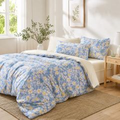 Bantry floral reversible duvet cover set in a bright, sunlit bedroom with a soft blue, yellow and white floral design.