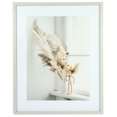 Beige photo frame front view with pampas grass arrangement and wooden mannequin in white vase by a window