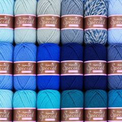 Three rows of neatly arranged Special yarn skeins in pastel blue, navy, teal, and turquoise shades, creating a colorful craft display.