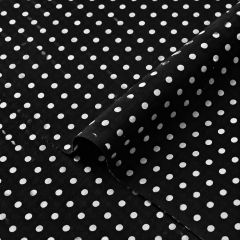Soft black georgette fabric with white polka dots draped into a gentle fold.