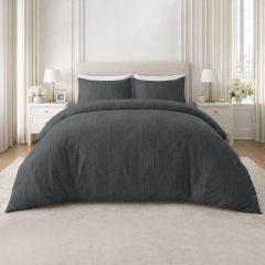 Charcoal embossed duvet cover set with a textured geometric design and matching pillowcases on a modern bed.