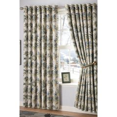 Elegant floral curtains with green and blue leaf patterns hang beside a window showing a snowy landscape. A framed picture sits on the windowsill.