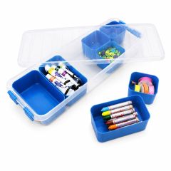 Clear plastic storage organiser box with removable blue compartments containing paints, crayons, ribbons and craft accessories, displayed with lid open.
