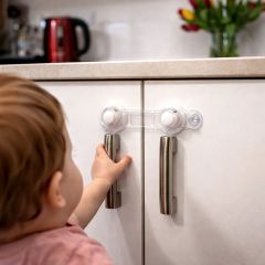 Clippasafe multi-purpose safety latch fitted to a kitchen cupboard to babyproof doors
