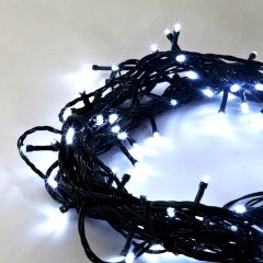 Cool white outdoor LED string lights illuminated on green wire, perfect for trees, fences, and holiday displays.