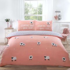 Cozy bedroom with a pink sheep-themed duvet and pillows, a window view of greenery, and decorative wall accents.
