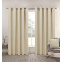 Natural Linen-colored curtains hang on a silver rod in front of a large window. A gray chair with a matching pillow is on the right, and a small table with a vase is on the left, creating a calm, cozy atmosphere.