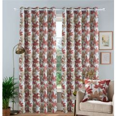 Floral patterned jacquard curtains in terracotta and beige hang in a cozy living room. A beige armchair with a matching cushion, houseplant, and floor lamp complete the decor.