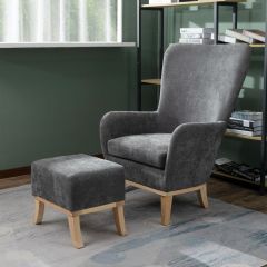 Grey upholstered armchair with matching footstool and wooden legs in living room setting