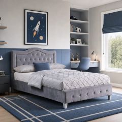 Grey upholstered bed with button-tufted headboard and footboard in a modern blue and grey boys' bedroom.