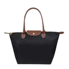A stylish black tote bag with brown leather handles and a flap. It features a gold button closure, exuding a classic and elegant appeal.