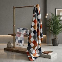 Multicoloured harlequin-check throws displayed on a wooden rail in a modern interior.