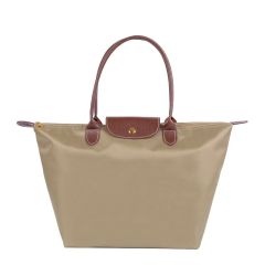 A stylish taupe tote bag with brown leather handles and a flap. It features a gold button closure, exuding a classic and elegant appeal.