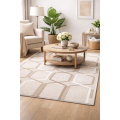 Cozy living room with a geometric beige rug, round wooden coffee table, cream armchair, and lush plants, creating a serene, elegant atmosphere.