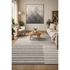 A cozy living room with neutral tones features a beige sofa and armchair, a wooden coffee table, and a geometric mountain art piece. Green plants add vibrancy.
