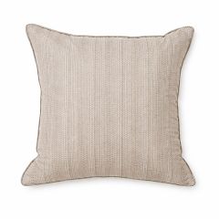 A textured, taupe cushion with subtle stripes sits on a matching herringbone-patterned armchair, creating a calm and coordinated aesthetic.