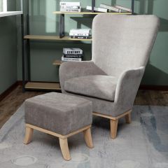 Grey upholstered armchair with matching footstool and wooden legs in living room setting