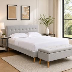 Light grey upholstered bed frame with tufted headboard and matching storage bench in a modern Scandinavian-style bedroom.