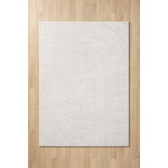 A light beige rug with a geometric pattern of thin, concentric circles and vertical lines, positioned on a wooden floor. The design conveys simplicity.