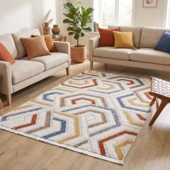 Modern multicolour geometric rug with blue, rust, mustard and neutral pattern in a bright living room.