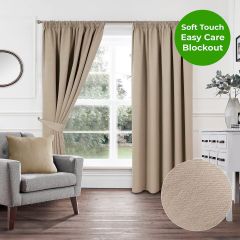 Natural soft touch blockout pencil pleat curtains styled in a bright modern living room with grey armchair