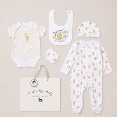 Neutral teddy bear print baby gift set with bodysuit, sleepsuit, bib, hat and mittens in presentation bag on beige background