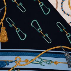 Navy and pale blue fabric patterned with teal clasps, knotted ropes, and tassels.
