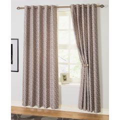 Taupe-patterned curtains hang on a brass rod in a bright room. One panel is tied back, revealing a window with a frame and soft natural light.
