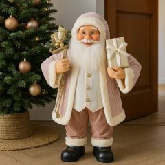 Pink Santa Claus Christmas figurine standing near a decorated tree and doorway with festive holiday lights and gifts