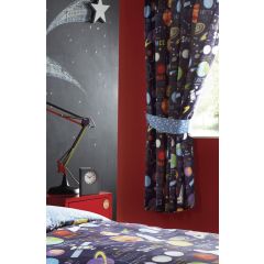 Children's room with a space theme. Starry chalkboard wall, colorful planet curtains, matching bedding, red wall and desk, and a sleek lamp create a playful atmosphere.