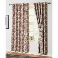 Floral-patterned curtains in brown and beige hang on a window with a silver rod. A framed butterfly photo rests on the windowsill, adding a cozy touch.
