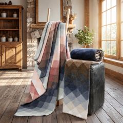 Prism-check throws in soft pink, blue, grey and brown tones displayed in a cosy living room.