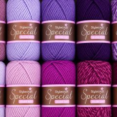 Close-up of Stylecraft Special double-knit yarn balls in lavender, purple, and magenta, arranged in rows with a cozy, creative craft mood.