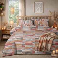 Cozy bedroom with a colorful geometric-patterned bedspread, wooden accents, candles, dried plants, and abstract wall art.