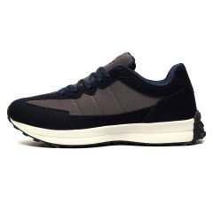 Dark blue and gray sneaker with a white sole, featuring a textured fabric and suede-like accents. The design is sleek and modern, conveying a sporty feel.