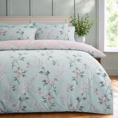 Duck egg floral duvet cover set with delicate pink blossoms, styled on a bed in a bright, modern bedroom.