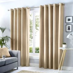 Natural Sorbonne eyelet curtains framing a window in a bright, modern living room.