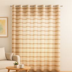 A beige and light-brown striped curtain hangs from a metal rod in a softly lit living room, with part of a cream sofa, a small wooden coffee table, and a framed pastel artwork visible on the left.