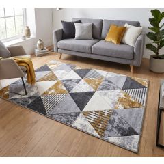 Modern geometric rug featuring a pattern of overlapping triangles in grey, mustard yellow, white, and blue tones with striped and textured detailing.