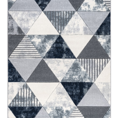 Contemporary rug with a geometric triangle pattern in shades of navy blue, grey, and white, featuring a mix of solid, textured, and striped designs