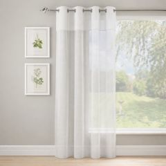 White sheer eyelet curtains gently filtering natural light in a modern living room window