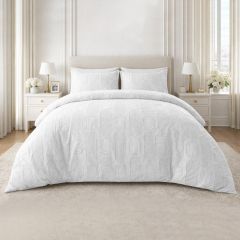 White embossed duvet cover set with a textured geometric design and matching pillowcases on a modern bed.
