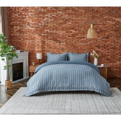 Blue striped duvet cover set with matching pillowcases, styled on a bed in a modern bedroom.