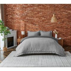 Charcoal striped duvet cover set with matching pillowcases, styled on a bed in a modern bedroom.